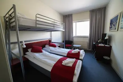 a hotel room with two bunk beds and a desk at Sitla Hotel & Apartments in Øvre Årdal