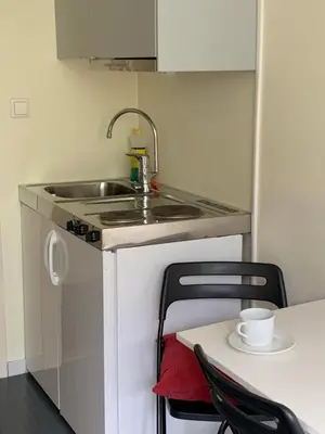 a small kitchen with a sink and a table at Sitla Hotel & Apartments in Øvre Årdal