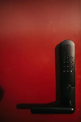 a remote control sitting next to a red wall at Nydelig moderne hytte på Geilo Kikut med høy standard - 4 senger 6 gjester in Geilo