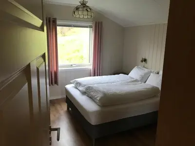 a bed in a room with a window and a bed sidx sidx sidx at Enesi holiday house in Hestenesøyra