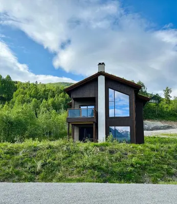 a small house on top of a grassy hill at Ground Floor Exclusive Apartment with Sauna - Near Geiranger and the Norwegian Fjords in Stranda
