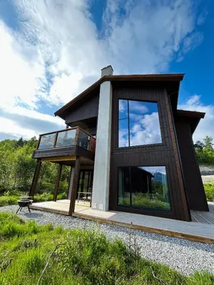 a house with glass windows on the side of it at Ground Floor Exclusive Apartment with Sauna - Near Geiranger and the Norwegian Fjords in Stranda