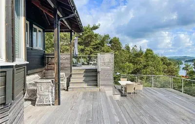 a wooden deck with a table and chairs on a house at Beach Front Home In Førde I Hordaland in Erve
