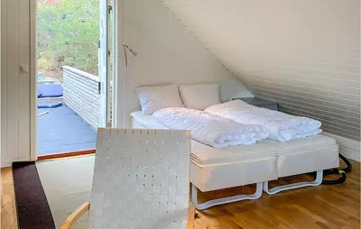 a bed sitting in a room next to a balcony at Beach Front Home In Førde I Hordaland in Erve