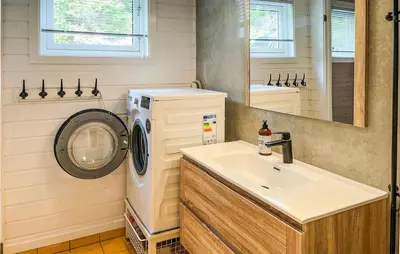 a bathroom with a washing machine and a sink at Beach Front Home In Førde I Hordaland in Erve