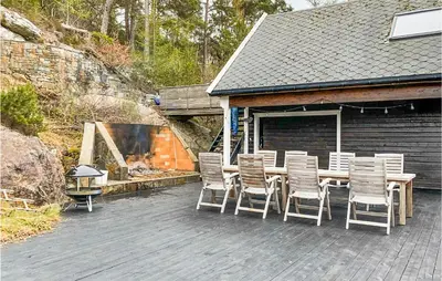 a wooden table and chairs on a patio at Beach Front Home In Førde I Hordaland in Erve