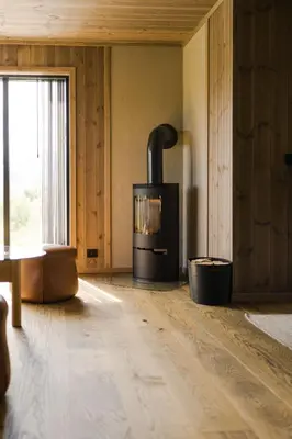 a living room with a wood stove in a room at Exclusive Nordic Apartment with Sauna - Prime Location at Stranda near Geiranger in Stranda