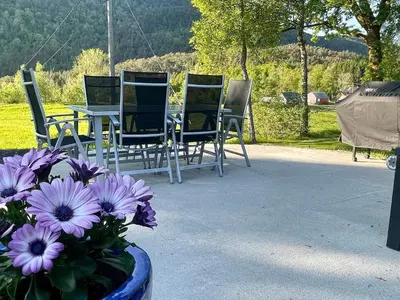 a group of chairs and a table and flowers at 4 person holiday home in OMASTRAND-By Traum in Sanddal
