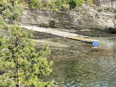 a blue box sitting on the shore of a body of water at 4 person holiday home in OMASTRAND-By Traum in Sanddal
