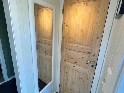 a closet with a wooden door in a room at 4 person holiday home in OMASTRAND-By Traum in Sanddal