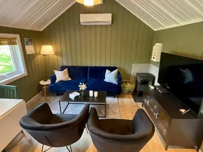 a living room with a blue couch and chairs at 4 person holiday home in OMASTRAND-By Traum in Sanddal
