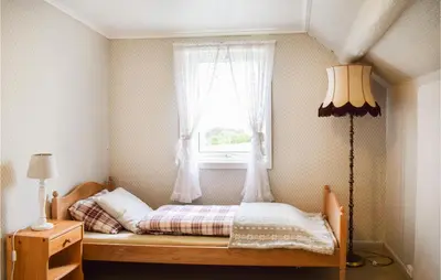 a small bedroom with a bed with a window at Beautiful Home In Sveio With Wifi in Sveio