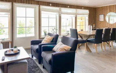 a living room with chairs and a table and windows at Amazing Home In Nordfjordeid With Wifi in Nordfjordeid