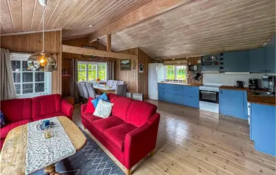 a living room with two red couches and a kitchen at 3 Bedroom Amazing Home In Lillehammer in Lillehammer