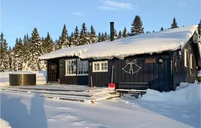 a cabin with snow on the roof in the snow at 3 Bedroom Amazing Home In Lillehammer in Lillehammer