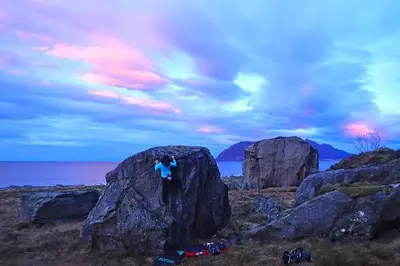 a person standing on top of a large rock at Beach front appartments in design eco-villa in Ulsteinvik
