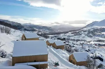 a village covered in snow with mountains in the background at Rindabotten Panorama in Sogndal