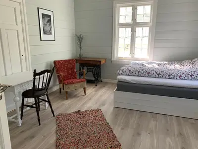 a bedroom with a bed and a desk and a chair at Valldal Sentrum Overnatting in Valldal
