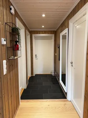 a hallway with wood paneling and a white door at Nice apartment on Geilotunet, Close to city center in Geilo