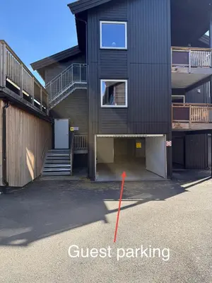 a building with a red pole in a parking lot at Nice apartment on Geilotunet, Close to city center in Geilo
