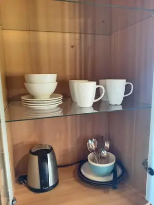 a shelf with cups and plates and utensils at LUBBENES GÅRD in Molde