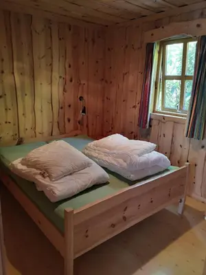 a bed in a wooden room with two pillows on it at Fanafjorden Cabins in Bergen