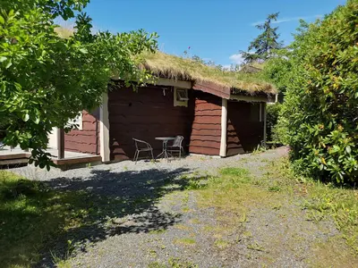 a house with a grass roof with a table outside at Fanafjorden Cabins in Bergen