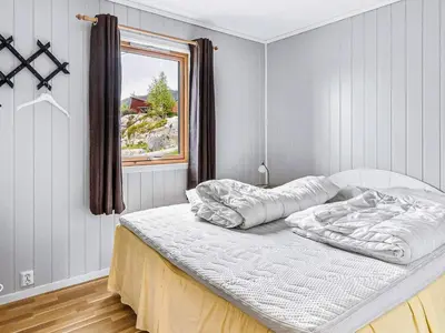 an unmade bed in a bedroom with a window at 6 person holiday home in Ånneland in Ånneland