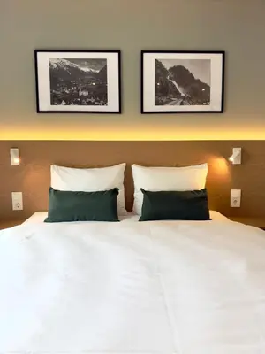 a bedroom with a white bed with two pillows at Odda City Apartments in Odda
