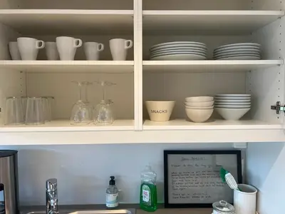 a kitchen shelf with dishes and plates on it at Fin leilighet med parkering! in Bergen
