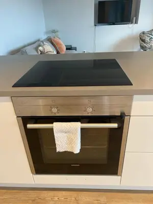 a kitchen with a oven with a towel on it at Fin leilighet med parkering! in Bergen