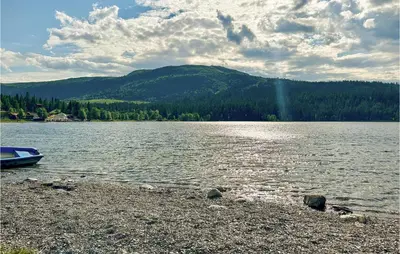 a boat sitting on the shore of a lake at Gorgeous Home In Gålå With Sauna in Gålå