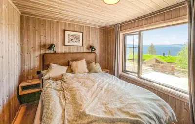 a bedroom with a bed and a large window at Gorgeous Home In Gålå With Sauna in Gålå