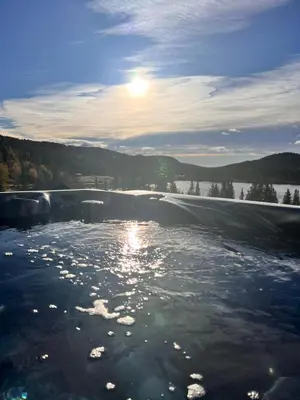 a body of water with the sun in the background at På solsiden av Gaustatoppen in Tuddal