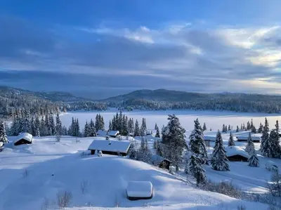 a house in the snow with a view of a lake at På solsiden av Gaustatoppen in Tuddal