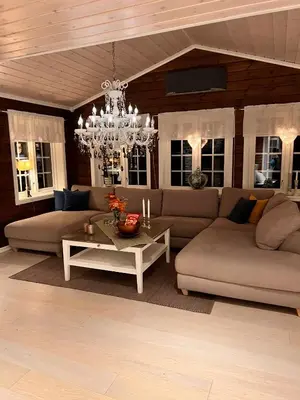 a living room with two couches and a chandelier at På solsiden av Gaustatoppen in Tuddal