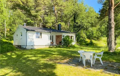 a white cottage with a table and chairs in the yard at 4 Bedroom Beach Front Home In Skodje in Skodje