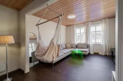 a hammock in a living room with a couch at Charming and bright apartment in Ålesund city in Ålesund