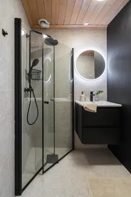 a bathroom with a glass shower and a sink at Charming and bright apartment in Ålesund city in Ålesund