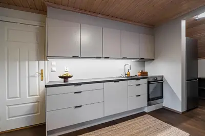 a kitchen with white cabinets and a sink at Charming and bright apartment in Ålesund city in Ålesund