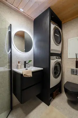 a bathroom with a sink and a washing machine at Charming and bright apartment in Ålesund city in Ålesund