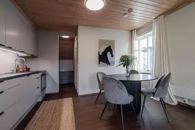 a kitchen with a table and chairs in a room at Charming and bright apartment in Ålesund city in Ålesund