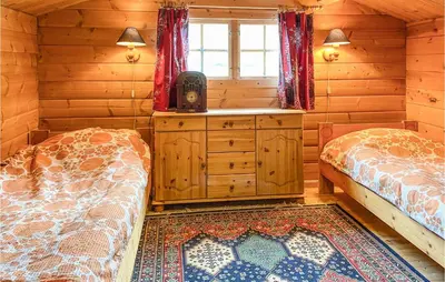 a bedroom with two beds in a log cabin at Nice Home In Selje With Wifi in Stokke