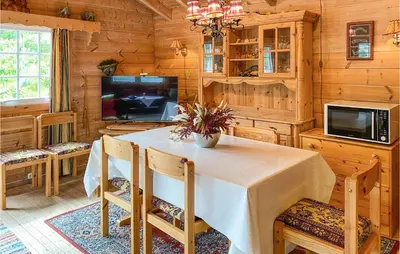 a dining room with a table and a tv at Nice Home In Selje With Wifi in Stokke
