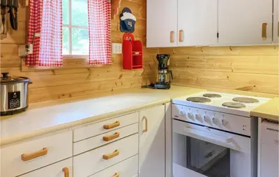 a kitchen with white cabinets and a stove top oven at Nice Home In Selje With Wifi in Stokke