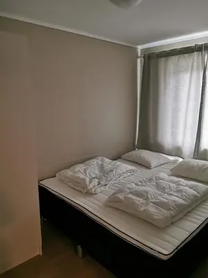 a bed with white sheets and pillows on it at Bøvervegen 19 Appartment nr 9 in Bjorli