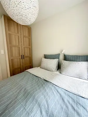 a bedroom with a large bed with a blue blanket at Knøsesmauet Apartment in Bergen