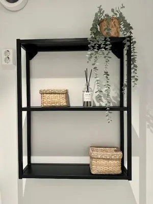 a black shelf with baskets and wicker baskets at Knøsesmauet Apartment in Bergen