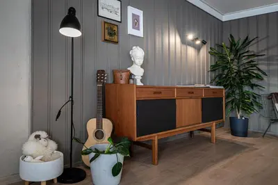 a living room with a dresser and a guitar in it at Fjord view apartment in Ålesund with free parking in Ålesund