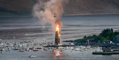 a fire in the water with boats in a harbor at Fjord view apartment in Ålesund with free parking in Ålesund
